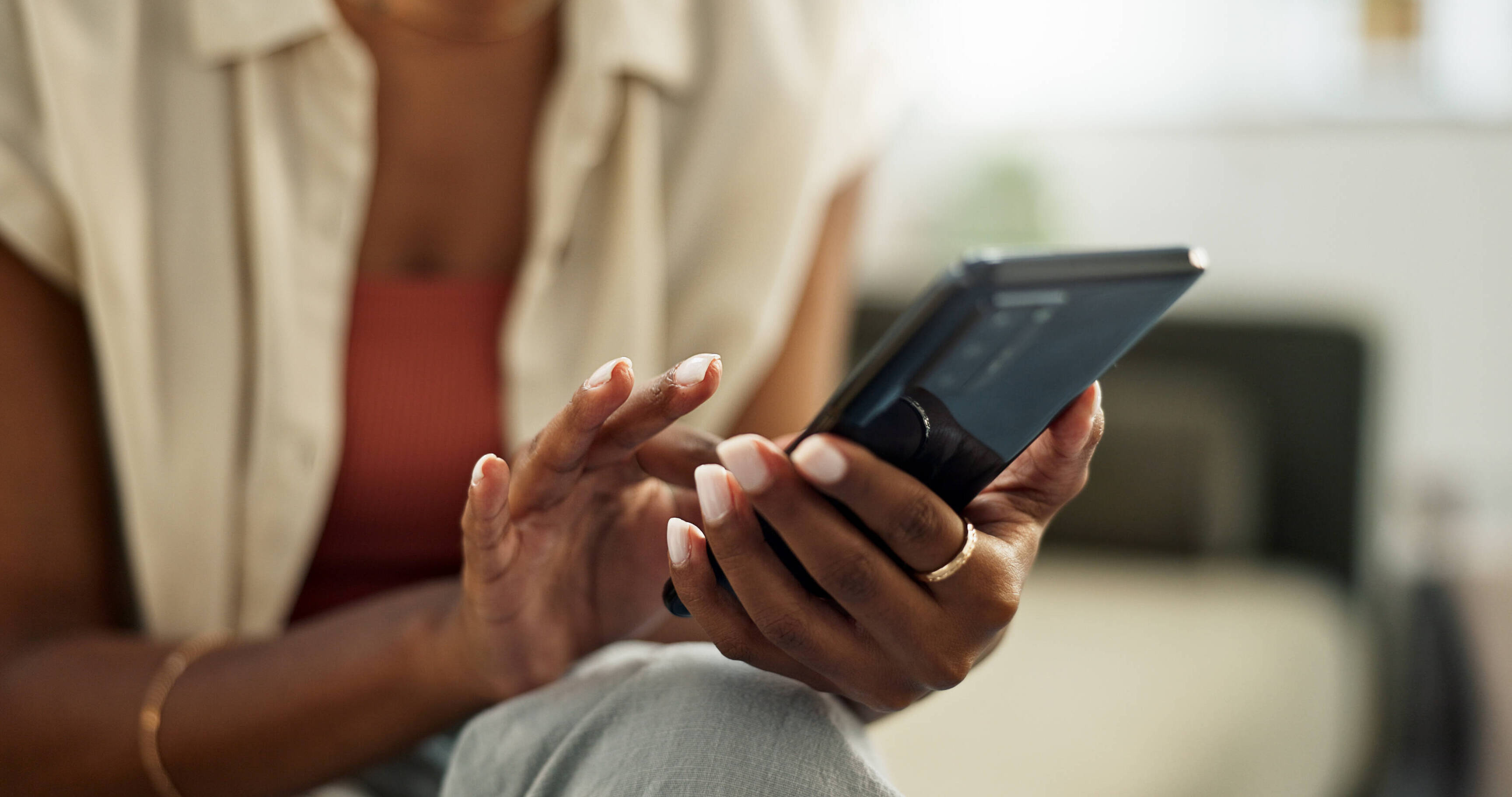 zoom photo mains femme tenant un smartphone pour lire une information sur son écran